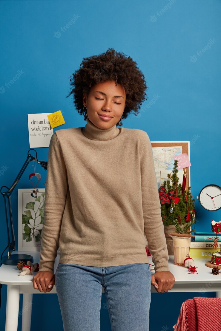 Beautiful African American Woman Leans Desktop Stands Against Workplace With Closed Eyes Wears Brown Casual Jumper Jeans 273609 34010