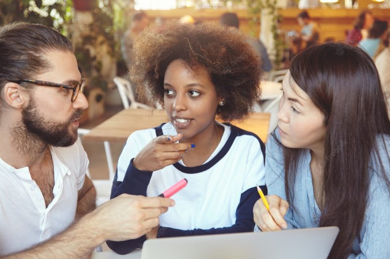 Brainstorm concept. man in glasses explaining ideas and vision to his female partners while having hot dispute on common project. Free Photo