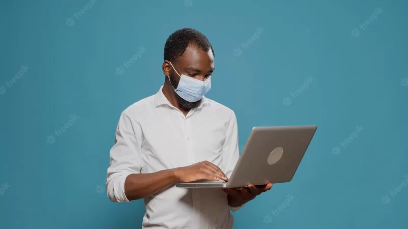 Businessman surfing internet website on laptop computer, working on social media app during coronavirus pandemic. young adult holding modern wireless gadget to browse online data. Free Photo