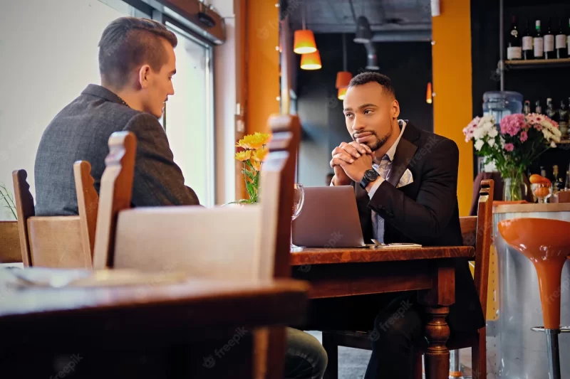 Caucasian and black american men having a business meeting in a restaurant. Free Photo