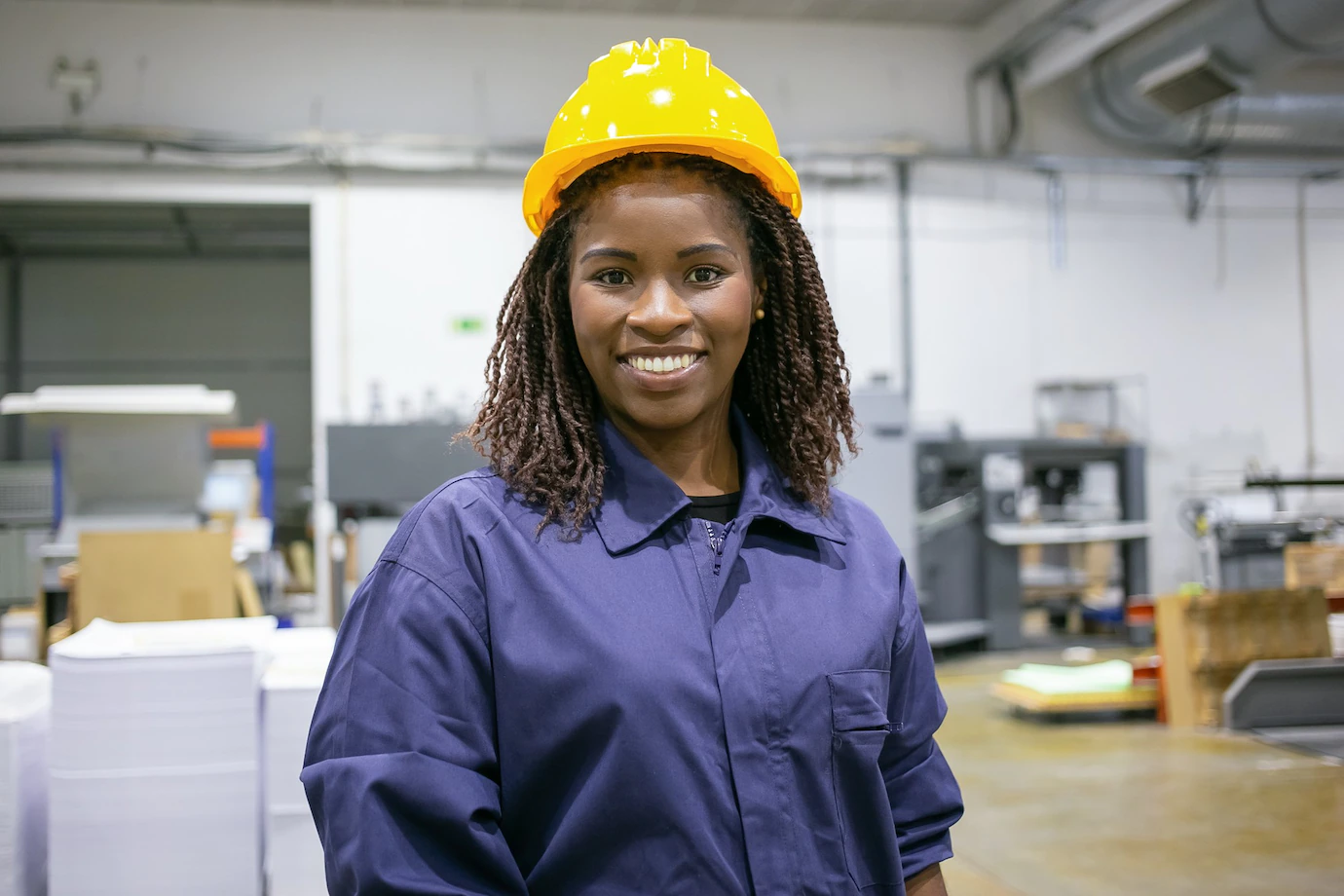 Cheerful African American Female Factory Employee Hardhat Overall Standing Plant Floor Looking Front Smiling 74855 16344