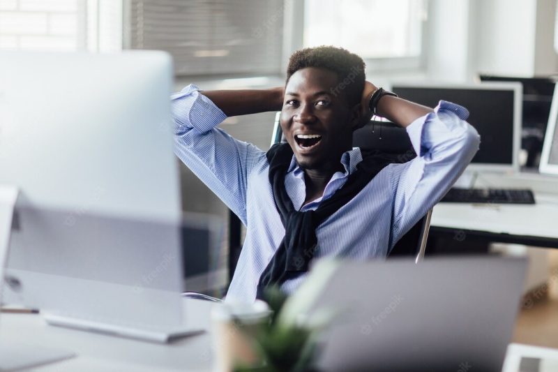 Cheerful entrepreneur at this office looking at monitor with a smile. candid emotions. Free Photo