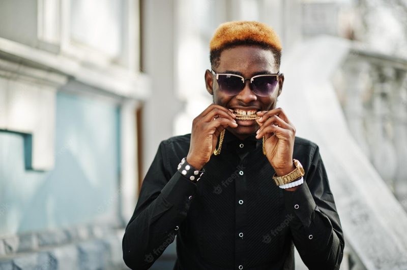 Chic handsome african american man in black shirt with gold chain and sunglasses Free Photo