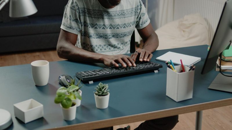 Close up of african american hands typing on computer keyboard for business remote work. black person working from home with gadgets and technology at desk with notebook. African American entrepreneur Free Photo