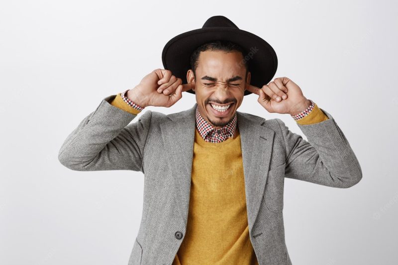 Close-up of annoyed and bothered African American guy shut ears with fingers, can’t stand annoying loud music Free Photo