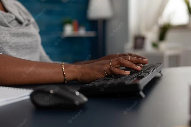 Close up of hands using keyboard to work on computer at desk. young woman working on business project with modern device and technology at home, browsing online internet website. Free Photo