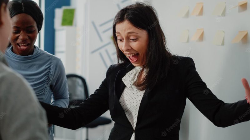 Close up of happy woman winning game at foosball table, playing with office coworkers after work. person enjoying free time and drinks to do fun activity with colleagues after hours. Free Photo