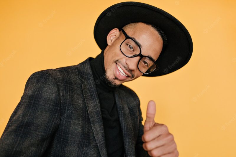 Close-up portrait of handsome black man with charming smile.well-dressed African guy wears hat and jacket. Free Photo