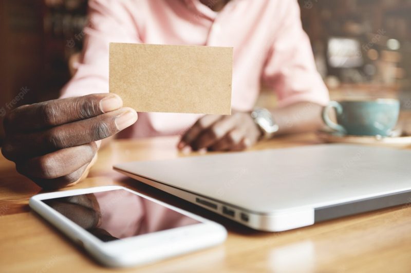 Close up shot of African corporate worker showing blank parchment card Free Photo