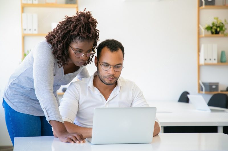 Concentrated African American woman looking at laptop Free Photo