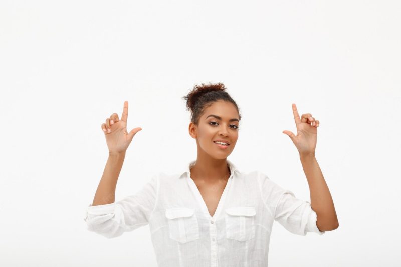 Confident African-American woman pointing up Free Photo