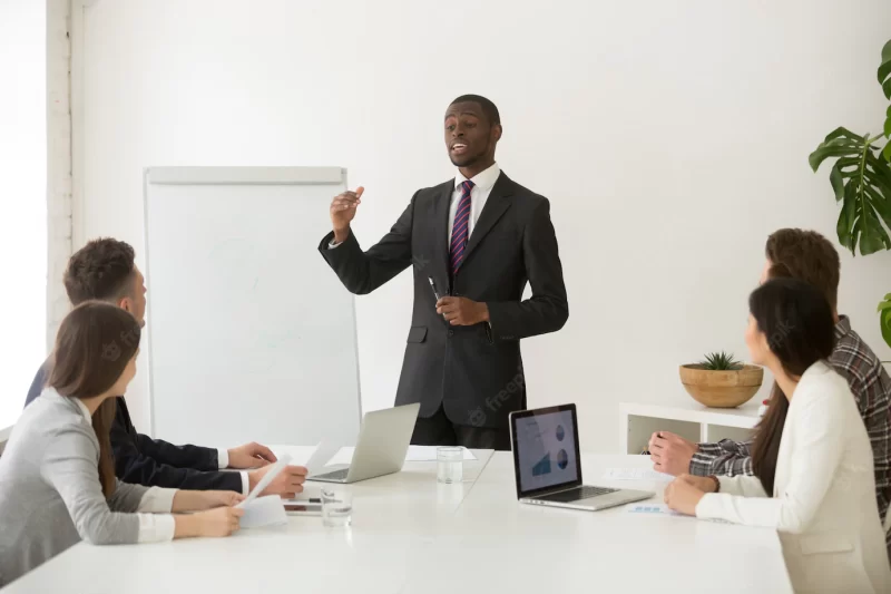 Confident african speaker or business coach giving presentation to team Free Photo