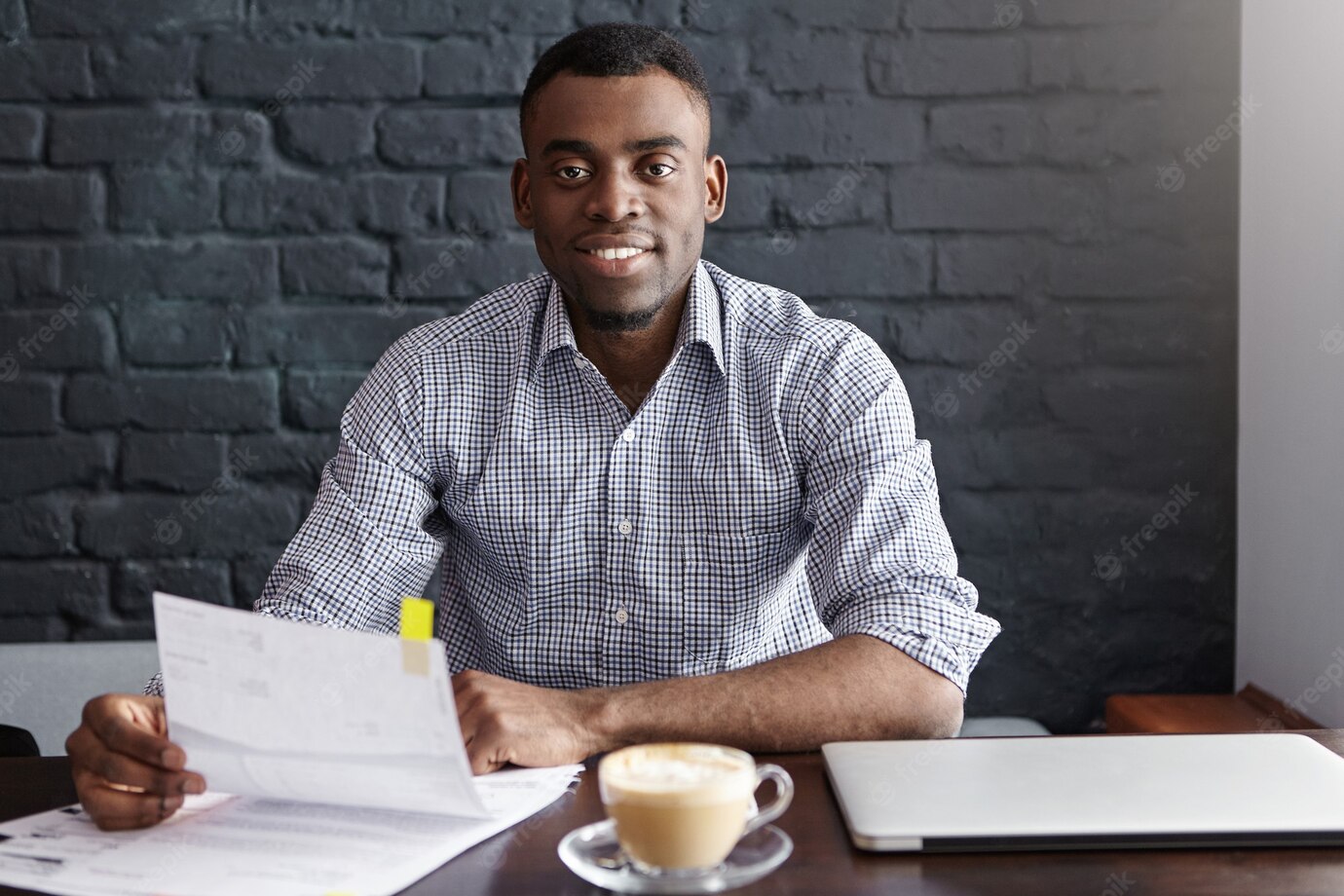 Confident Young African Businessman Wearing Formal Shirt Sitting Table With Laptop Mug Papers 273609 9105