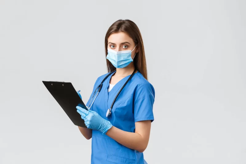 Covid-19, preventing virus, health, healthcare workers and quarantine concept. professional female nurse or doctor in blue scrubs, medical mask and gloves, writing down patient info using clipboard Free Photo Covid-19, preventing virus, health, healthcare workers and quarantine concept. professional female nurse or doctor in blue scrubs, medical mask and gloves, writing down patient info using clipboard Free Photo