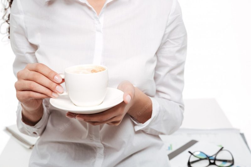 Cropped image of African business woman drinking coffee Free Photo