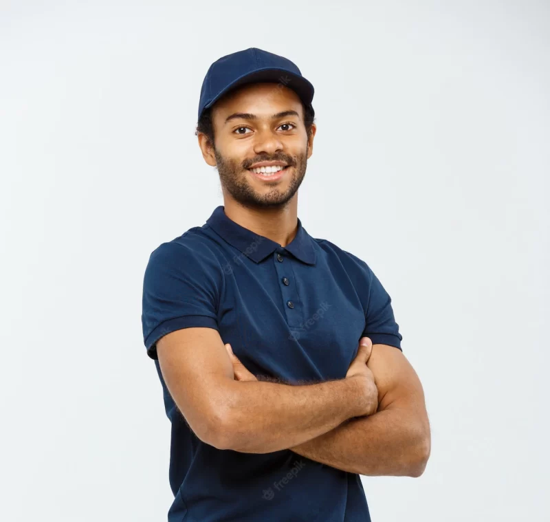 Delivery concept – handsome african american delivery man crossed arms over isolated on grey studio background. copy space. Free Photo