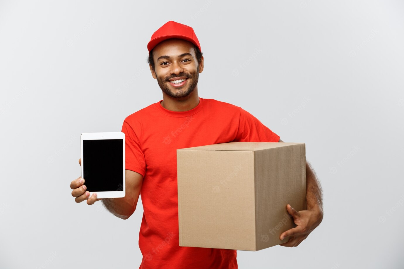 Delivery Concept Portrait Handsome African American Delivery Man Courier With Box Showing Tablet You Check Order Isolated Grey Studio Background Copy Space 1258 1204