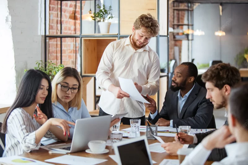 Diverse group of co-workers having casual discussion in office Free Photo