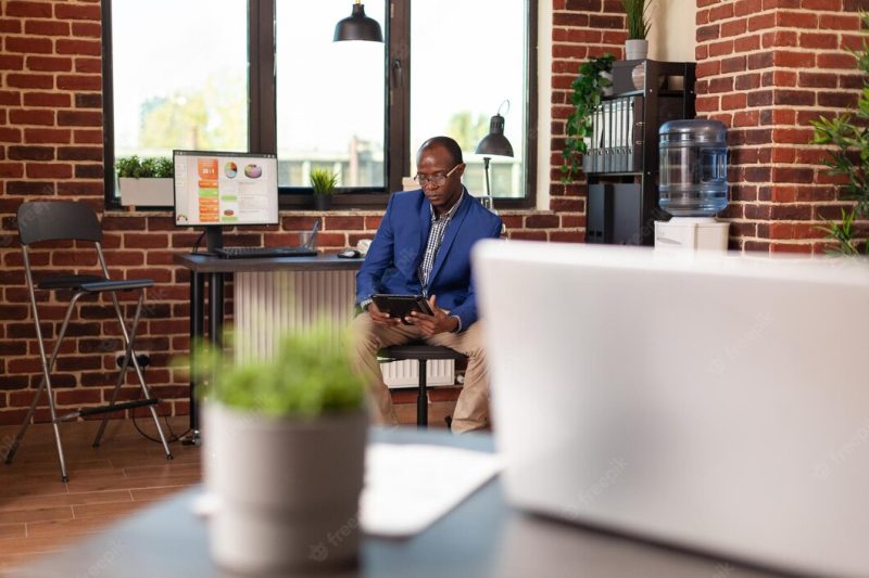 Employee using digital tablet to work on marketing strategy at workplace. business man working on internet with gadget to plan financial project, brainstorming ideas for startup company. Free Photo