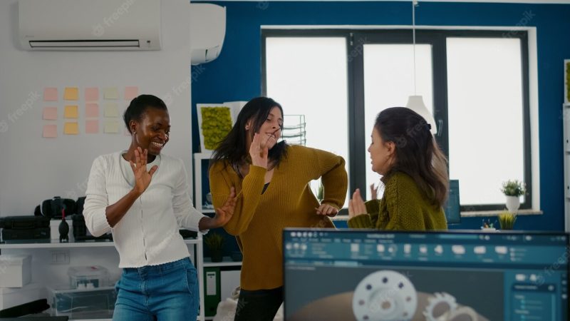 Enthusiastic diverse engineers women dancing in company office celebrating success of project  dancing… Free Photo