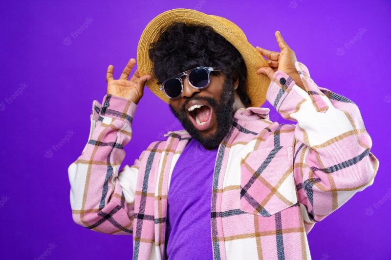 Fashion portrait of african american man in glasses against purple background Free Photo