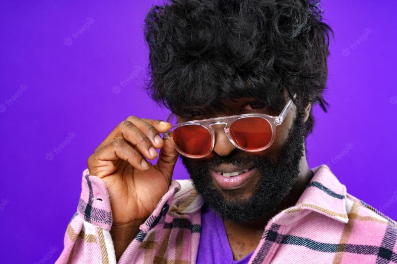 Fashion portrait of african american man in glasses against purple background Free Photo