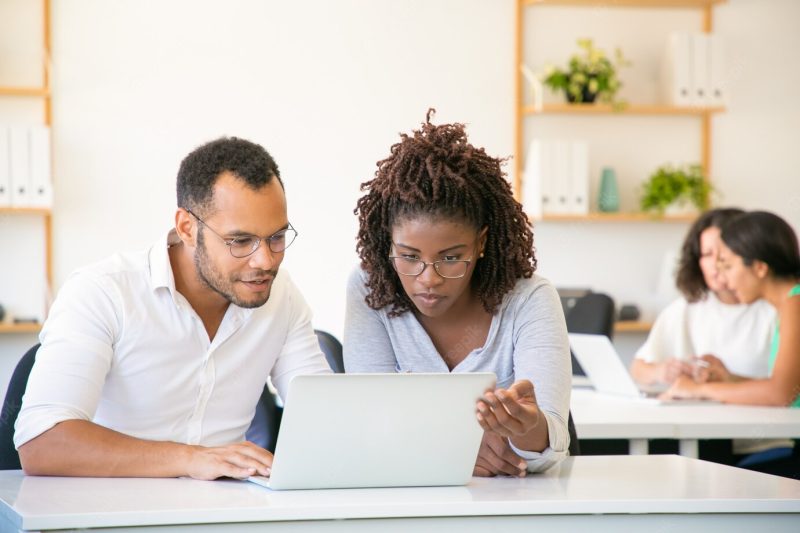 Front view of concentrated employees working with laptop Free Photo