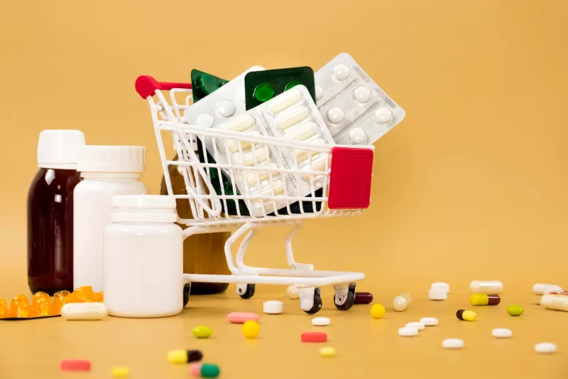 Front view of shopping cart with pill foils and containers Free Photo