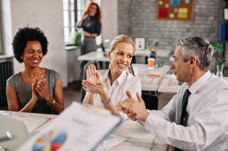 Group of happy business colleagues clapping hands after attending an presentation in the office Free Photo