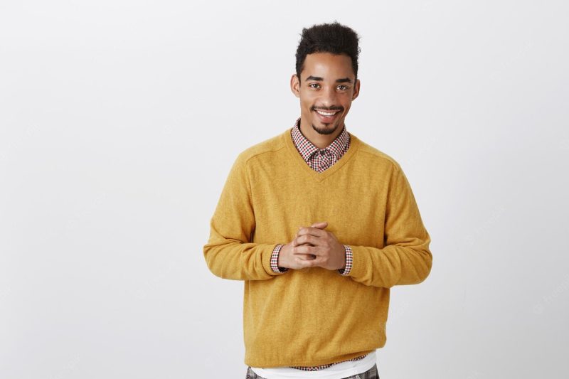 Handsome insecure African-American with Afro hairstyle holding hands together over chest, feeling confident, worrying Free Photo