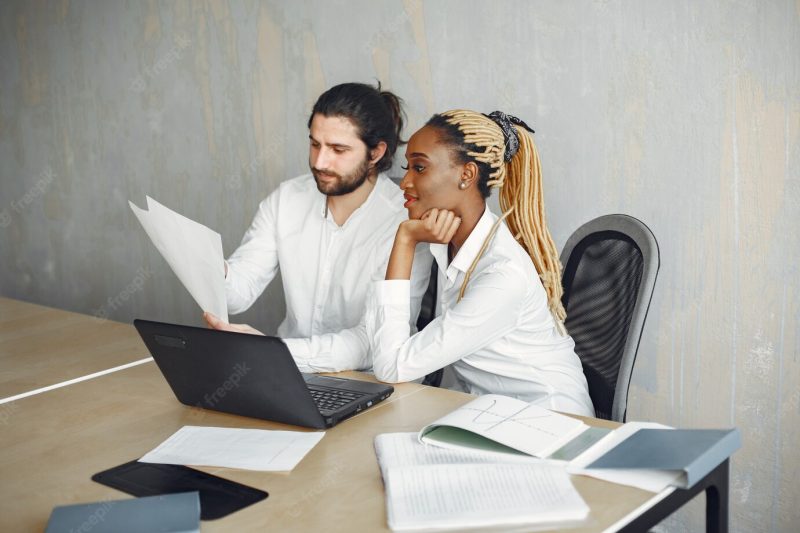 Handsome man in a white shirt. african woman with partner. guy with a laptop. Free Photo