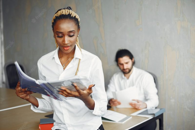 Handsome man in a white shirt. african woman with partner. guy with a laptop. Free Photo