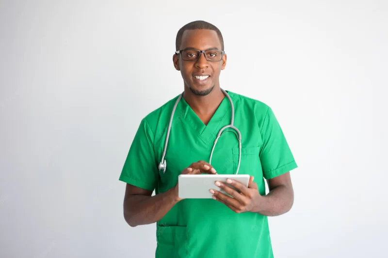 Happy black male doctor using tablet computer. technology in medicine concept. Free Photo