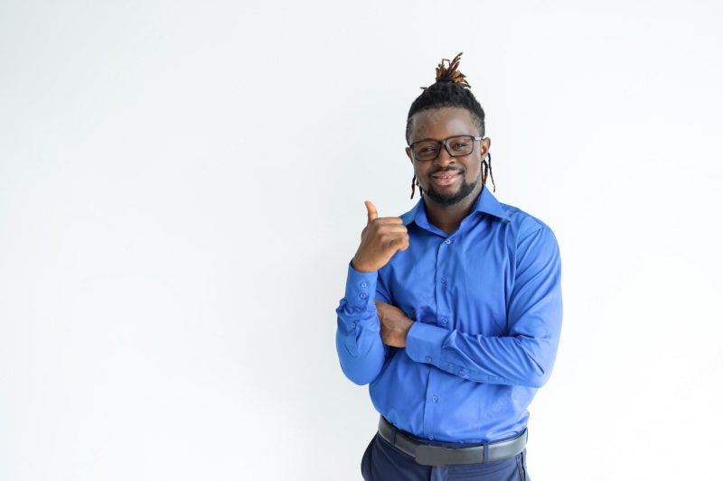 Happy black man showing thumb up and looking at camera Free Photo