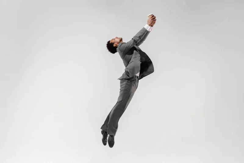 Happy businessman dancing in motion isolated on white studio background. flexibility and grace in business. human emotions concept. office, success, professional, happiness, expression concepts Free Photo