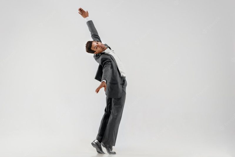 Happy businessman dancing in motion isolated on white studio background. flexibility and grace in business. human emotions concept. office, success, professional, happiness, expression concepts Free Photo