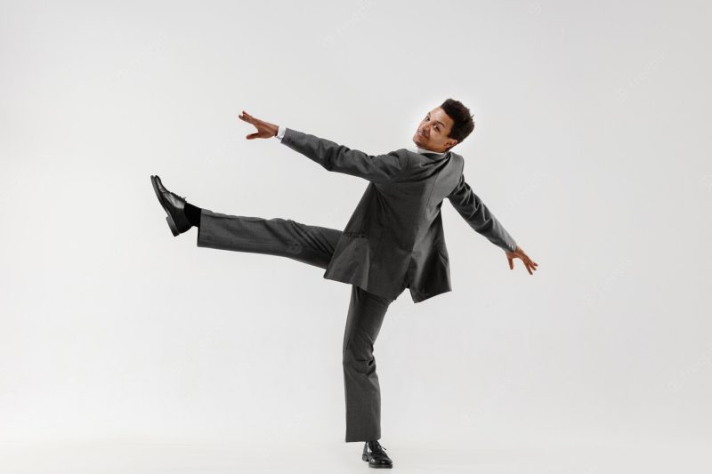 Happy businessman dancing in motion isolated on white studio background. flexibility and grace in business. human emotions concept. office, success, professional, happiness, expression concepts Free Photo