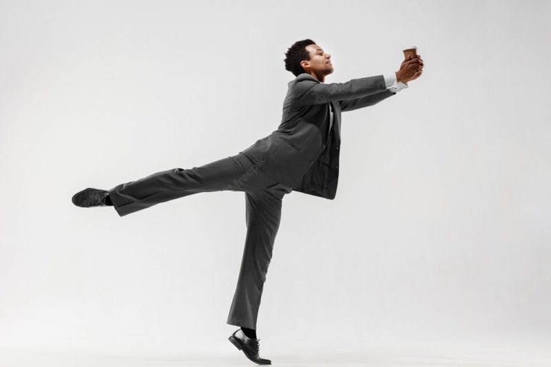 Happy businessman dancing in motion isolated on white studio background. flexibility and grace in business. human emotions concept. office, success, professional, happiness, expression concepts Free Photo