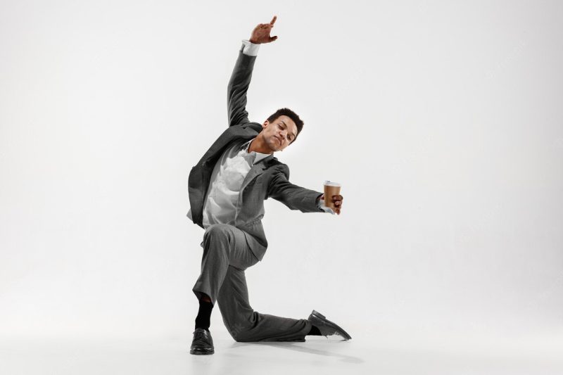 Happy businessman dancing in motion isolated on white studio background. flexibility and grace in business. human emotions concept. office, success, professional, happiness, expression concepts Free Photo