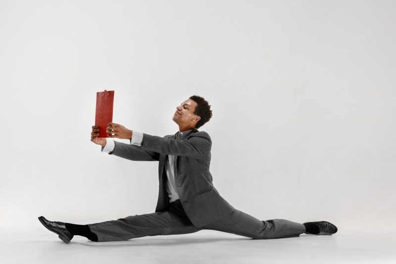 Happy businessman dancing in motion isolated on white studio background. flexibility and grace in business. human emotions concept. office, success, professional, happiness, expression concepts Free Photo