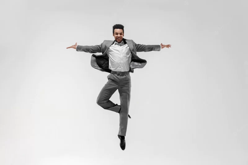 Happy businessman dancing in motion isolated on white studio background. flexibility and grace in business. human emotions concept. office, success, professional, happiness, expression concepts Free Photo