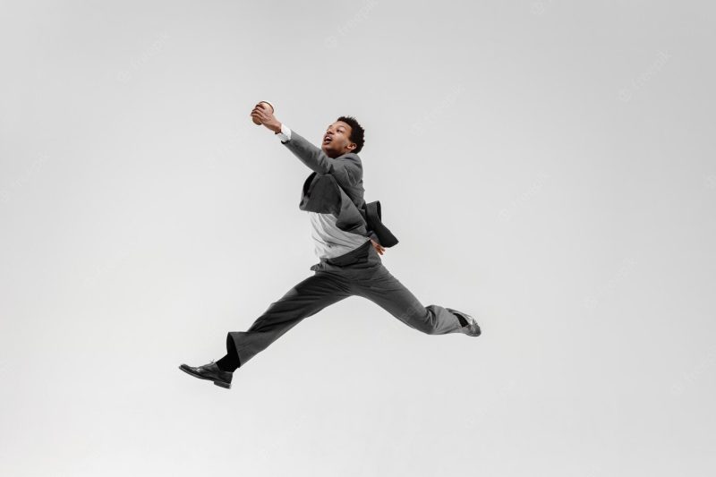 Happy businessman dancing in motion isolated on white studio background. flexibility and grace in business. human emotions concept. office, success, professional, happiness, expression concepts Free Photo