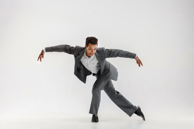 Happy businessman dancing in motion isolated on white studio background. flexibility and grace in business. human emotions concept. office, success, professional, happiness, expression concepts Free Photo