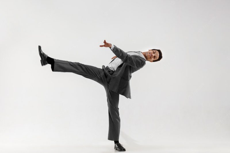 Happy businessman dancing in motion isolated on white studio background. flexibility and grace in business. human emotions concept. office, success, professional, happiness, expression concepts Free Photo