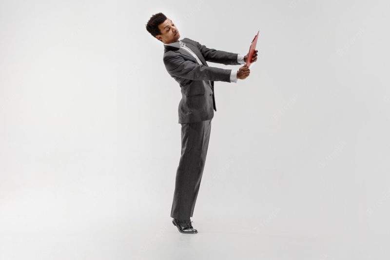 Happy businessman dancing in motion isolated on white studio background. flexibility and grace in business. human emotions concept. office, success, professional, happiness, expression concepts Free Photo