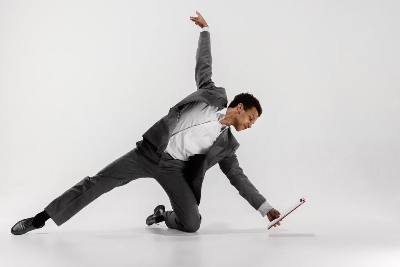 Happy businessman dancing in motion isolated on white studio background. flexibility and grace in business. human emotions concept. office, success, professional, happiness, expression concepts Free Photo