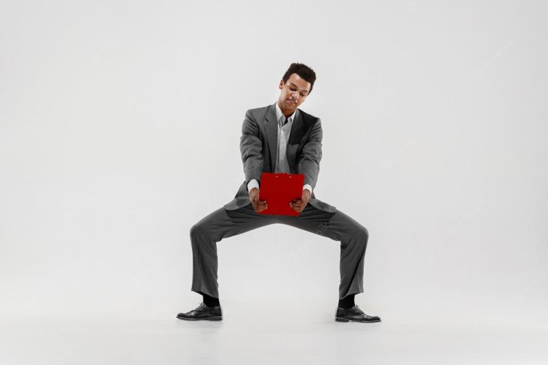 Happy businessman dancing in motion isolated on white studio background. flexibility and grace in business. human emotions concept. office, success, professional, happiness, expression concepts Free Photo