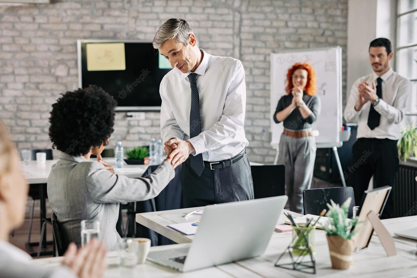 Happy Businessman His African American Female Colleague Shaking Hands After Successful Agreement Office While Other Coworkers Are Applauding Them 637285 200