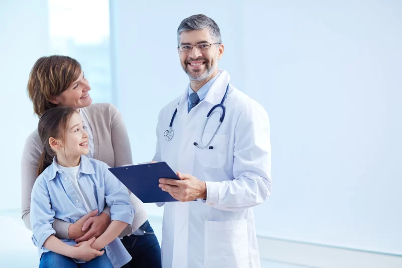 Happy doctor holding a clipboard with patients Free Photo Happy doctor holding a clipboard with patients Free Photo