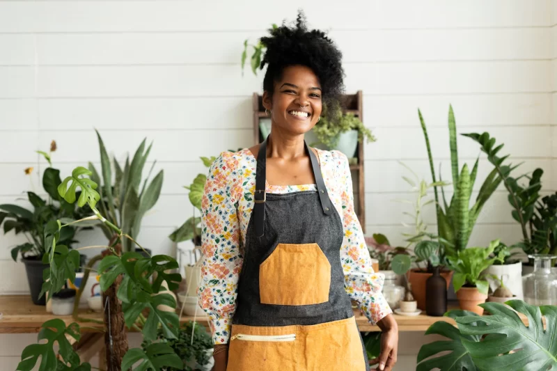 Happy small business owner at a plant shop Free Photo